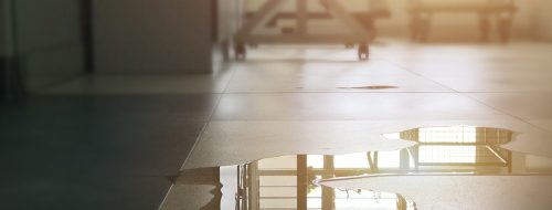 A water leak on the floor of a residential building, identified as clean water, the first type of water classification.